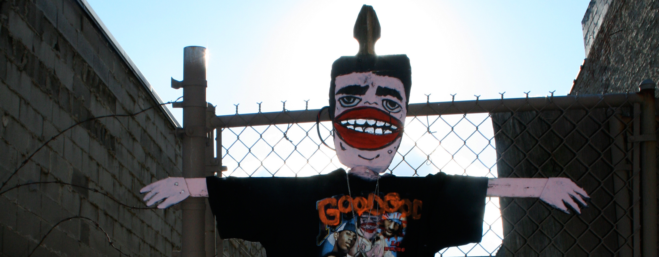 Goons figure in front of a fence